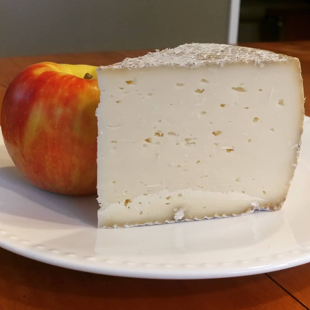 It has begun! I managed to separate this attractive wedge from the giant wheel and will be taking it to work to "share." I also had my first taste of the and it is delightful! Firm, but not hard. Tangy, sharp, creamy...I didn't know what I'm saying. It's delicious! Thank you @sweetgrassdairy!